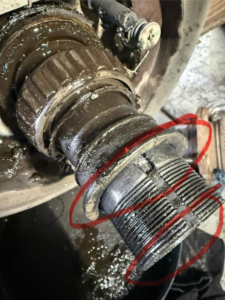 Damaged threads and spacer on a LandCruiser axle housing, circled in red