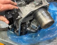 Used VW DSG mechatronic unit marked Polo on the workbench after removal