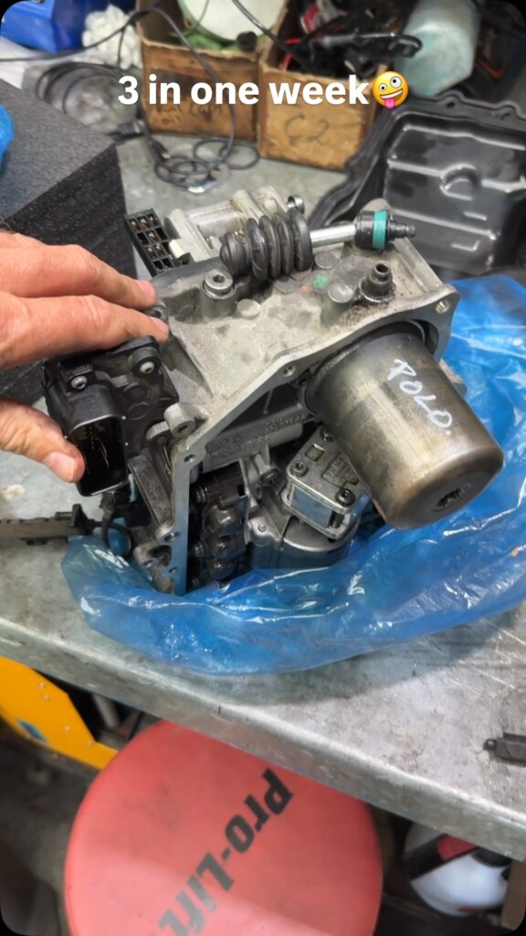 Used VW DSG mechatronic unit marked Polo on the workbench after removal
