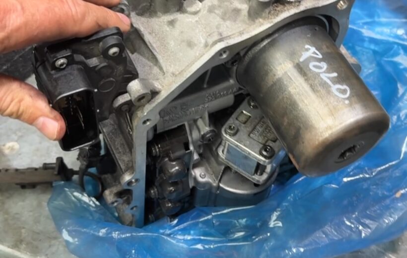 Used VW DSG mechatronic unit marked Polo on the workbench after removal